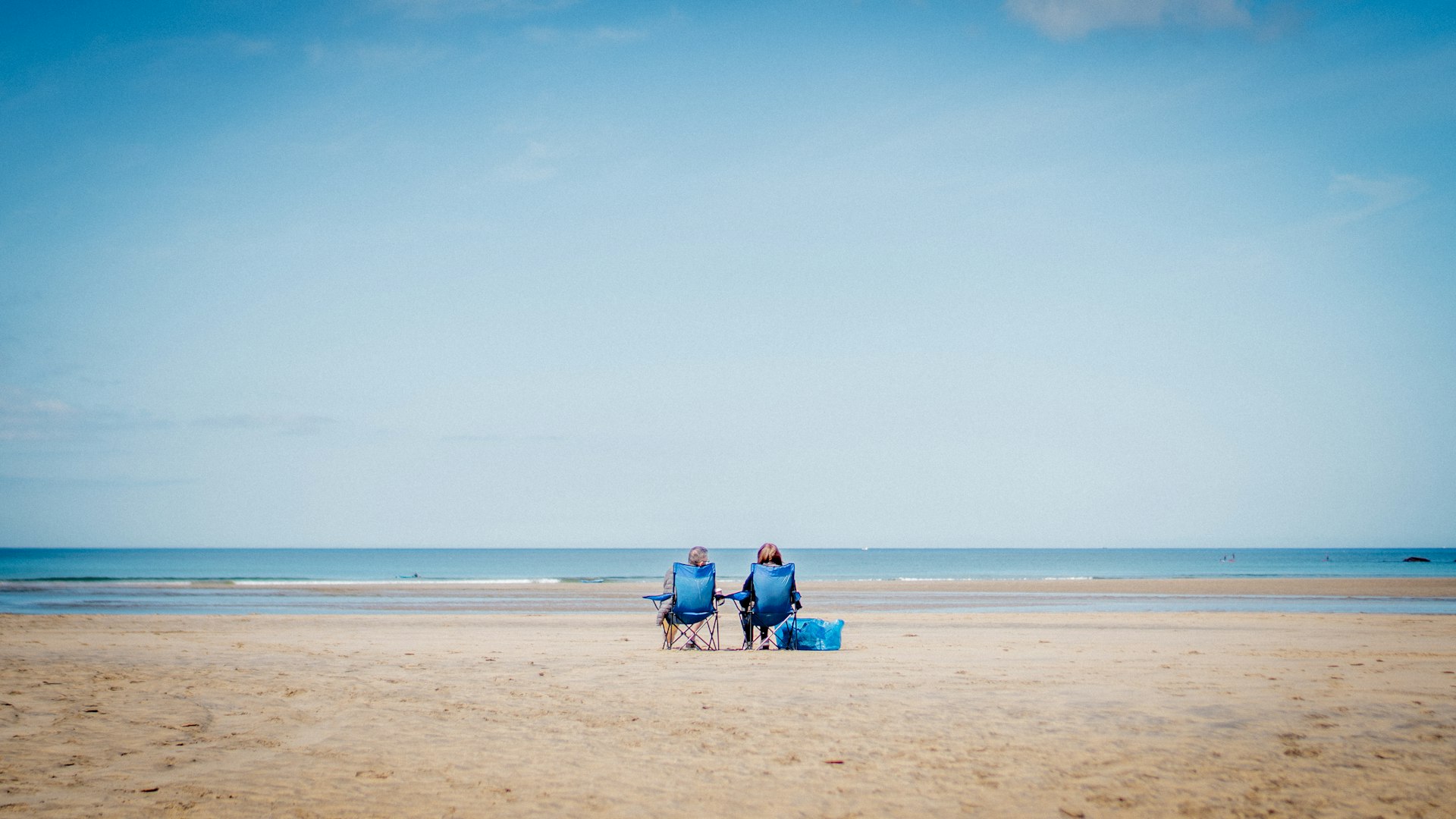 Photo of two people sitting on the beach